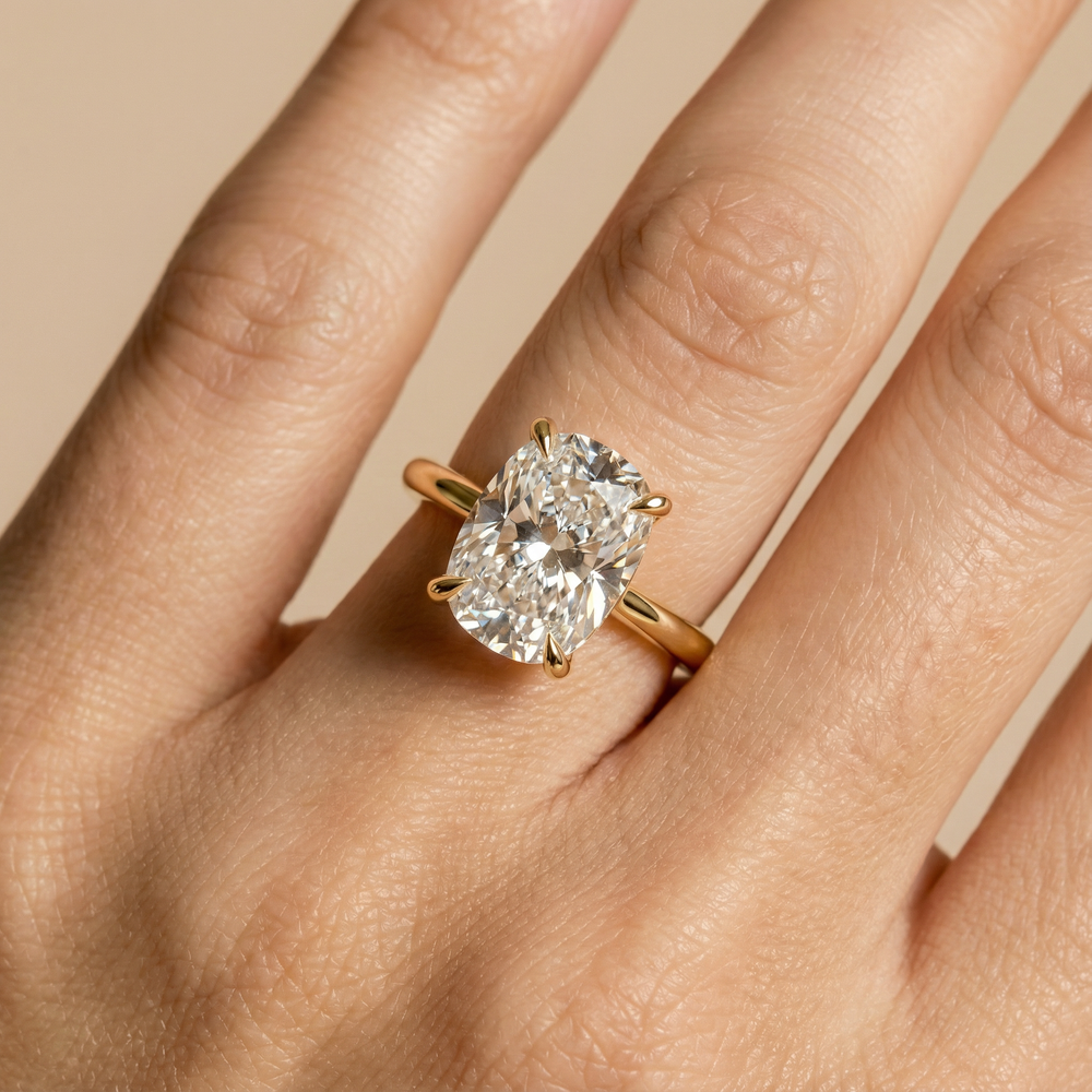 Hand wearing a gold ring with a large oval diamond solitaire