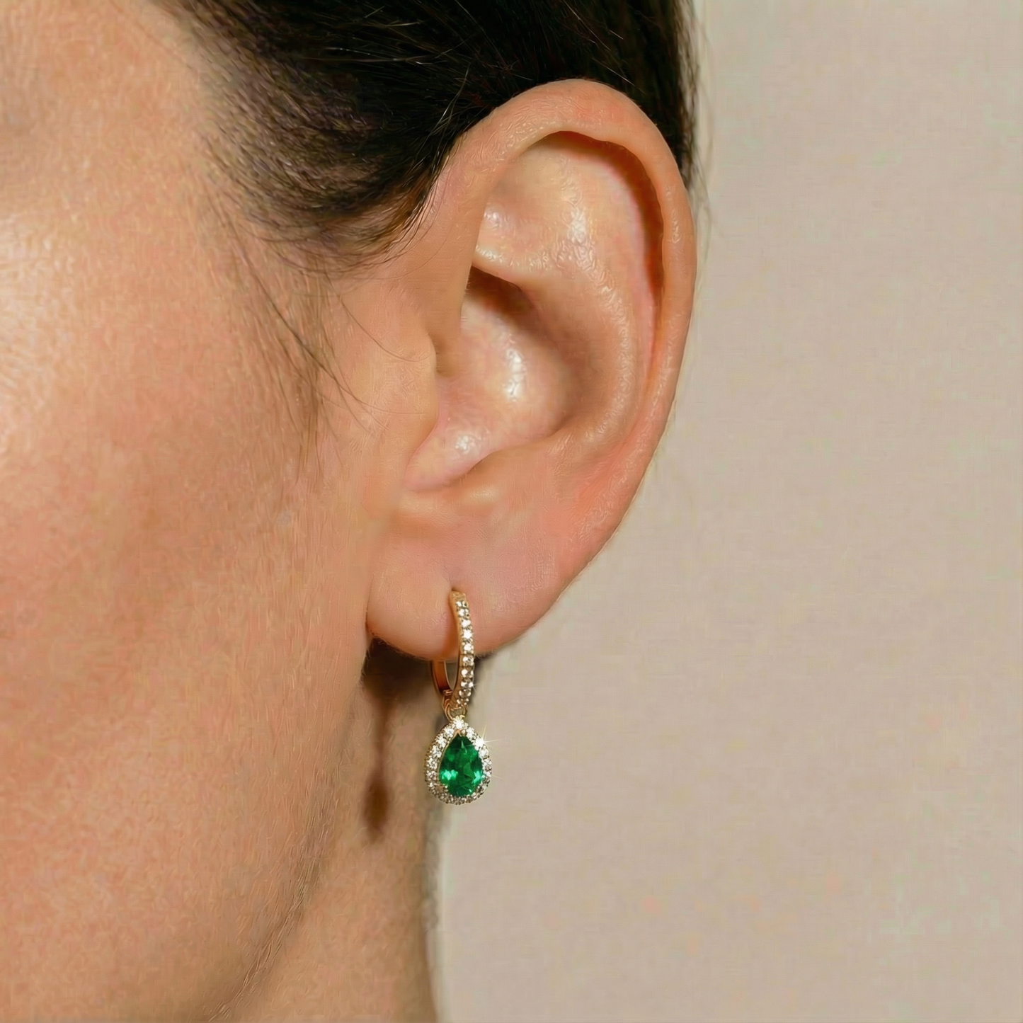 
                  
                    Elara 18ct and 22ct yellow Gold huggie hoop earrings with a emerald stone-set pear drop, by Karat Goldsmiths
                  
                
