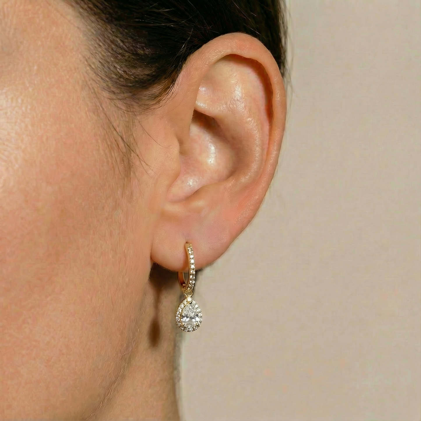 Elara 18ct and 22ct yellow Gold huggie hoop earrings with a clear stone-set pear drop, by Karat Goldsmiths