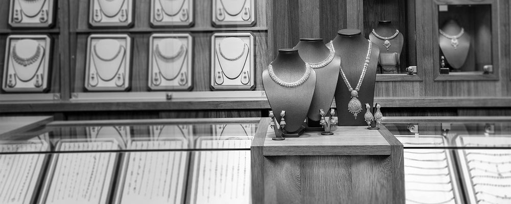 Jewelry store display with necklace busts, rings, and earrings behind a glass counter