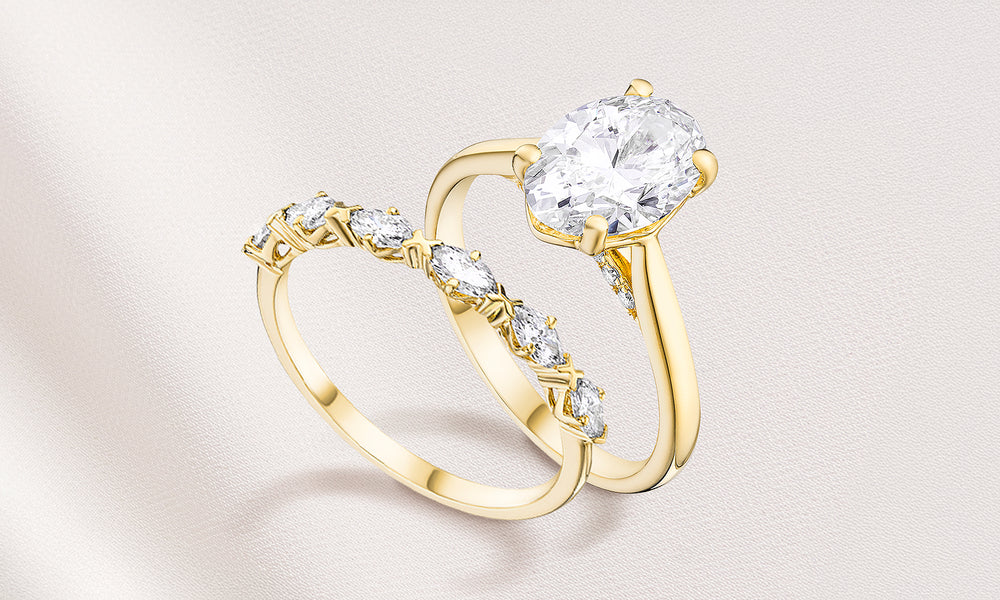 Two gold diamond rings on a light fabric background